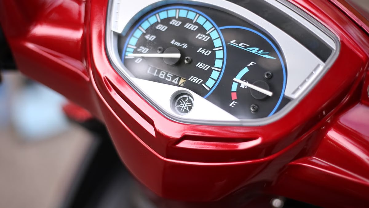 Close-up view of a red motorcycle speedometer displaying km/h and fuel gauge.